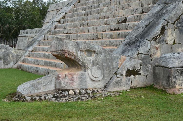A feathered serpent sculpture at the base of one of the stairways of El Castillo, Chichen-Itza, Mexico
