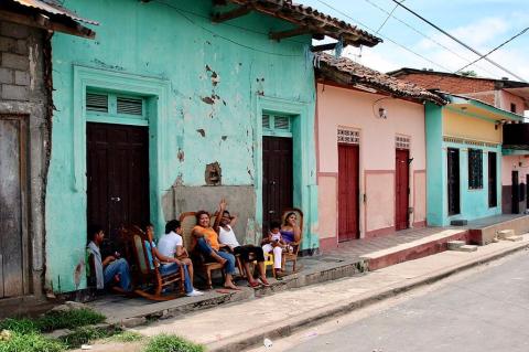 Family gathered outside colorful houses in Granada, Nicaragua